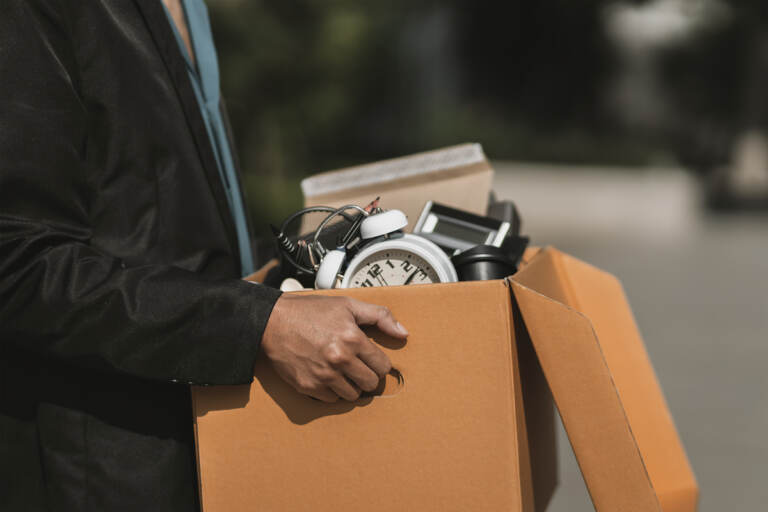 A man who has been fired or has resigned from their company walks out carrying boxes. (Big Stock/Charnchai Saeheng