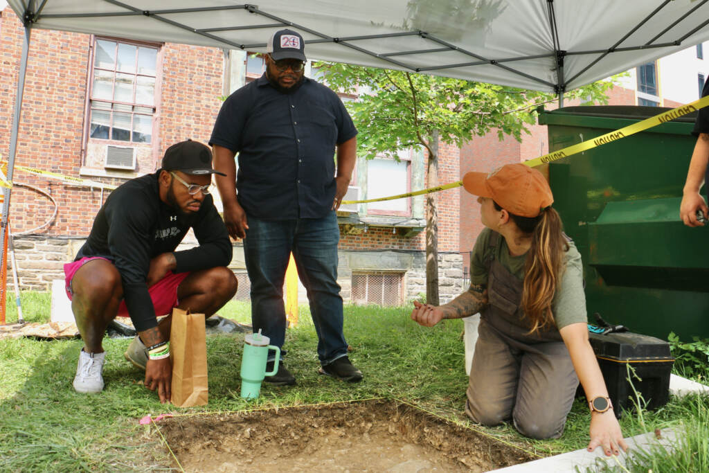 Penn anthropology student Autumn Melvin shares the day's finds with community activists Chris Burney (left) and James Wright.