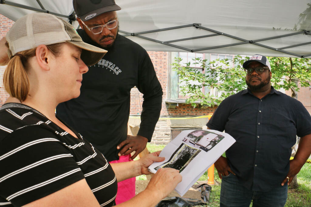 Archaeologist Megan Kassabaum shows someone a piece of paper showing radar.