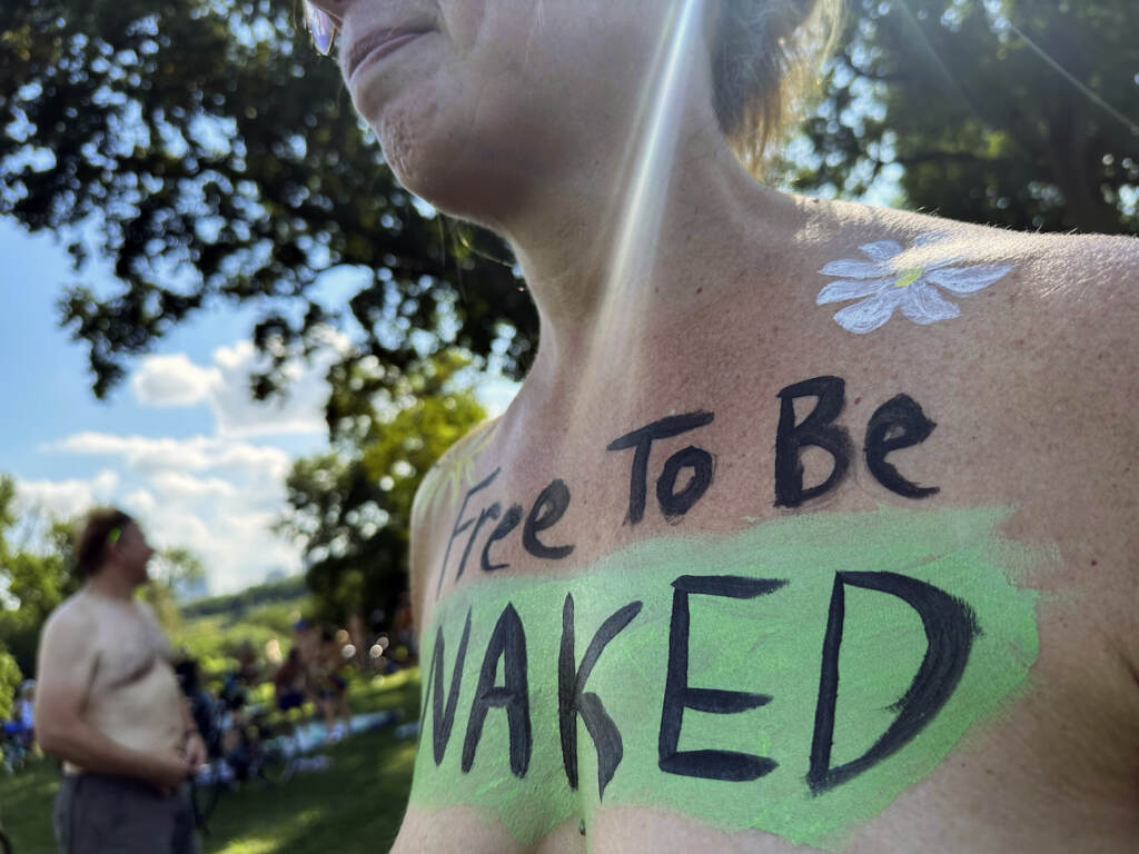 Philly Naked Bike Ride A woman with the phrase 'Free To Be Naked' written across her bare chest.