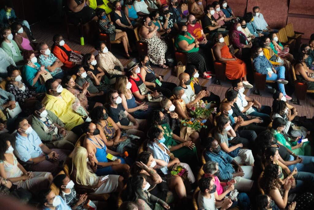 Attendees at the BlackStar Film Festival sit in rows, as seen from above and off to the side.