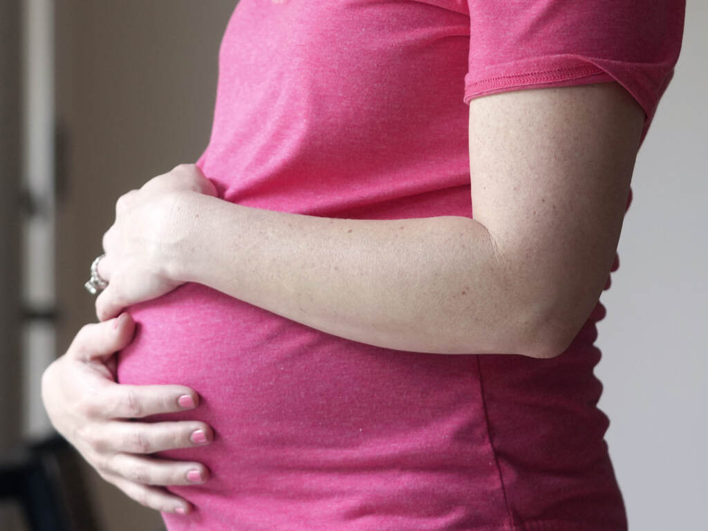 A pregnant woman stands for a portrait in Dallas on May 18. U.S. health officials have approved the first pill specifically intended to treat severe depression after childbirth, a condition that affects thousands of new mothers in the U.S. each year. A pregnant woman holds her belly.