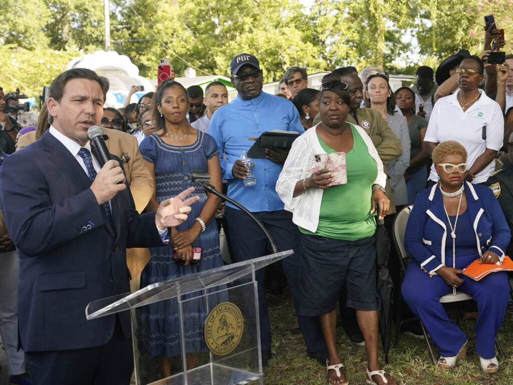 Florida Gov. Ron DeSantis, left, speaks at a prayer vigil on Sunday for the victims of a mass shooting that took place Saturday in Jacksonville, Fla. Florida Gov. Ron DeSantis, left, speaks at a prayer vigil on Sunday for the victims of a mass shooting that took place Saturday in Jacksonville, Fla.