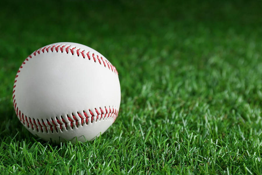 A baseball is visible on the grass