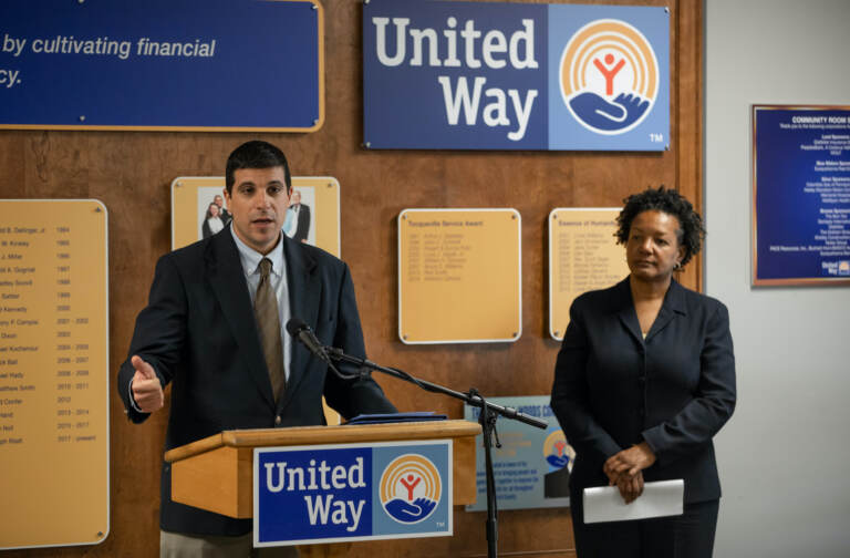 Patrick Cicero speaking at a podium, standing next to Gladys Brown