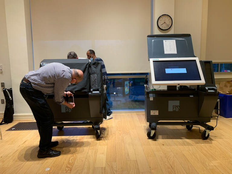 election worker fixing a voting machine
