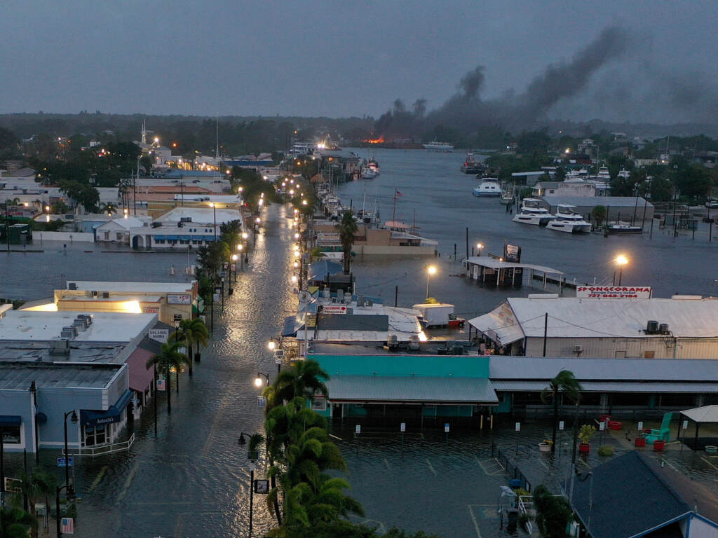In an aerial view, a fire is seen as flood waters inundate the downtown area after Hurricane Idalia passed offshore Wednesday in Tarpon Springs, Fla. In an aerial view, a fire is seen as flood waters inundate the downtown area after Hurricane Idalia passed offshore Wednesday in Tarpon Springs, Fla.
