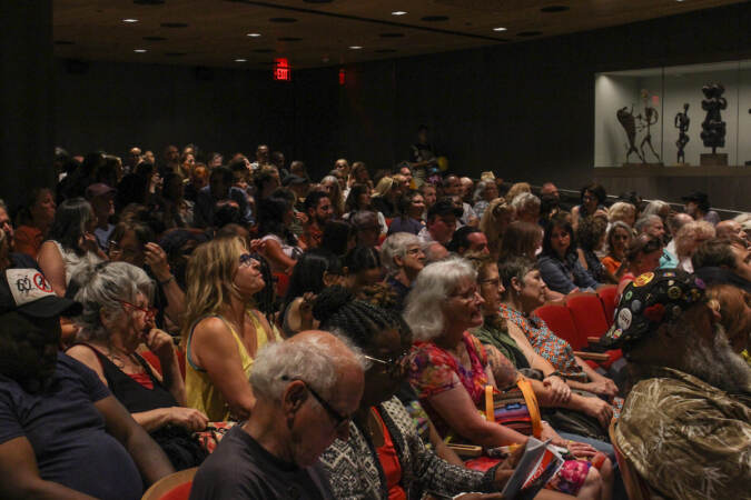Audience members look on.