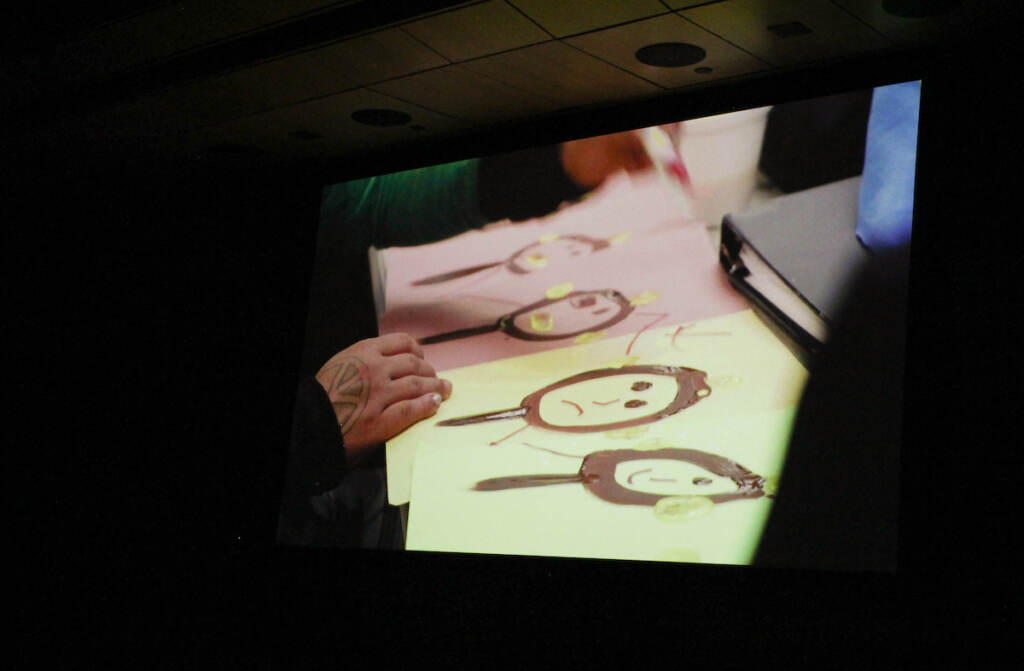 A screen shows someone creating artwork.