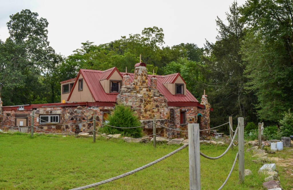 A stone and brick red-roofed house with several towers is visible.