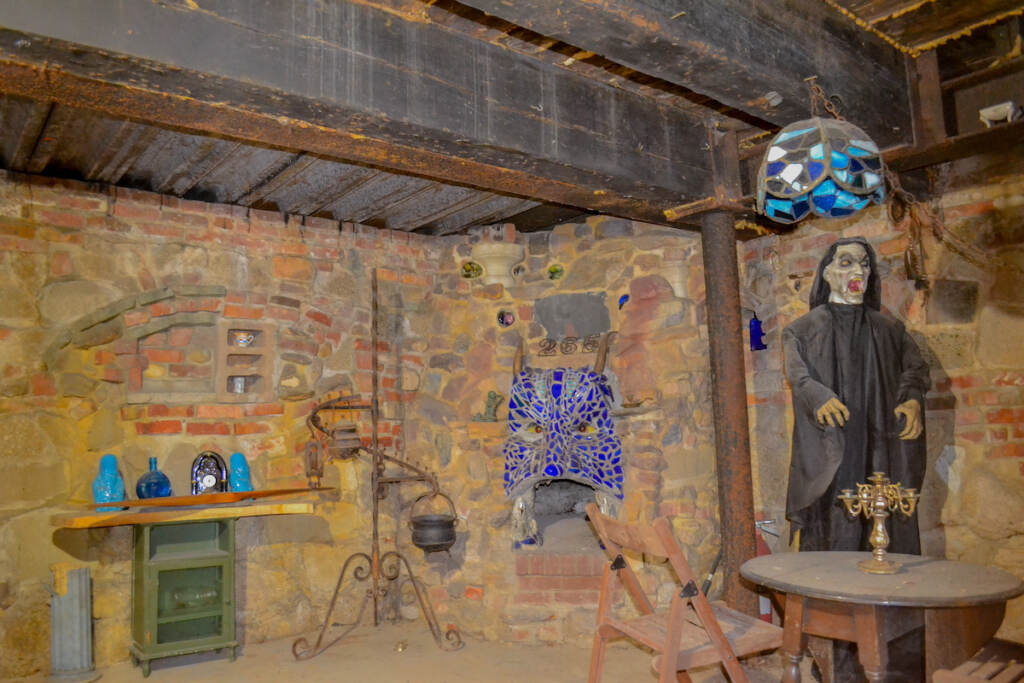A room with a strange mask on the wall and a Dracula-like figure.
