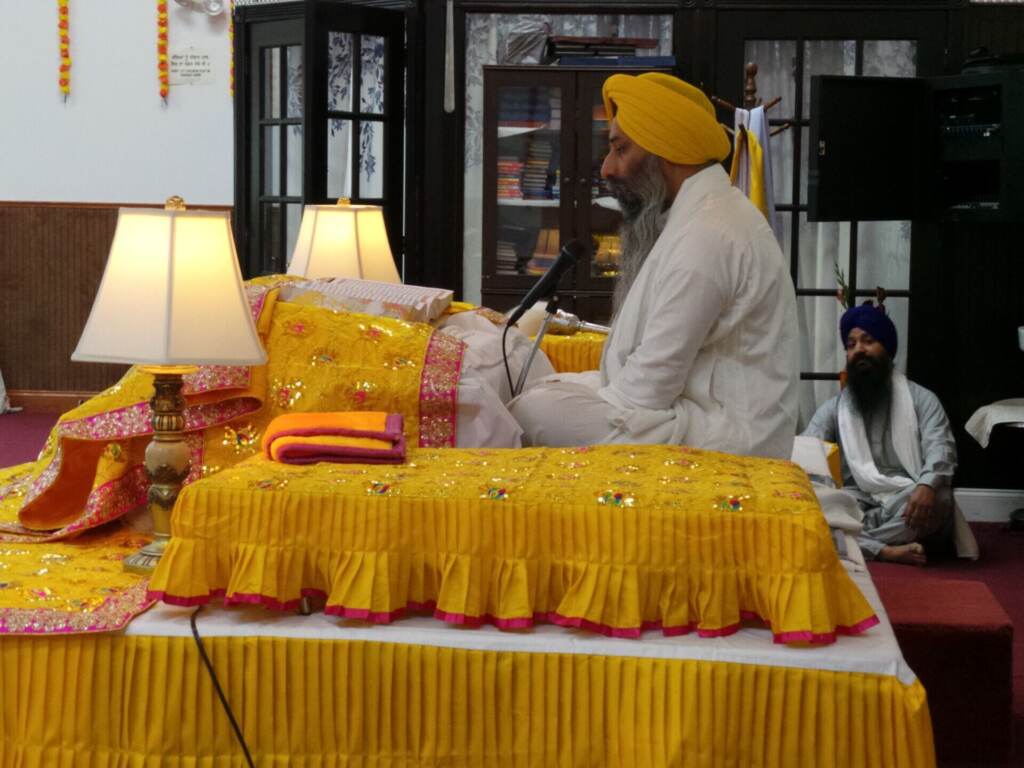 sikhism-new-jersey Head Priest Giani Gurjit Singh recites hymns from the Sikh Holy Scripture as members of sangat (community) listen.