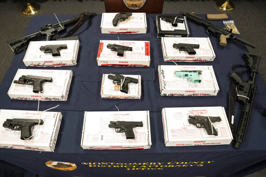 Gun Traffickers Arrested Allegedly straw purchased weapons are laid out on a table.
