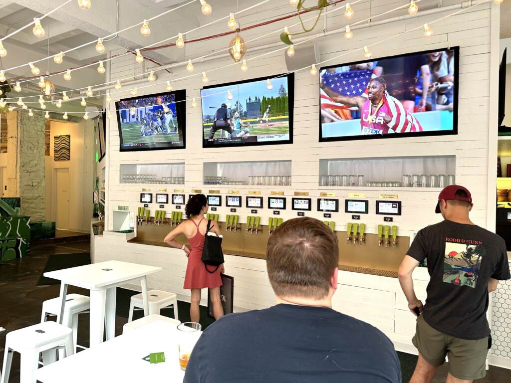 people lined up at a row of taps at the bar Tapster