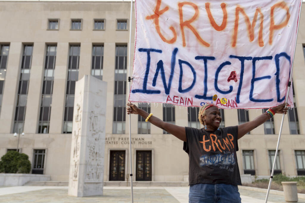 Trump Capitol Riot Nadine Seiler holds up a sign that says, ''Trump indicted again and again'' outside federal court