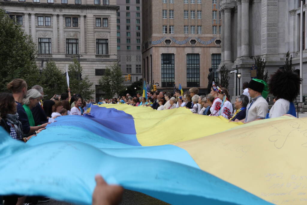 ukraine-flag-raising-15 Attendees hold a huge Ukrainian flag outside of City Hall.
