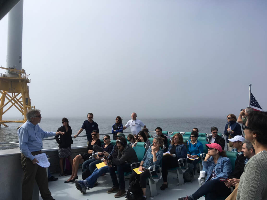 Willett Kempton speaking to a large group of people on a boat.