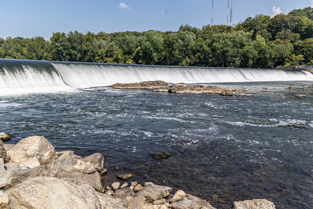 A view of the Flat Rock Dam as water pours down a slight incline.