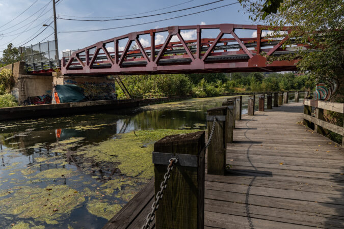 A bridge is visible near a pathway next to the Manayunk Canal