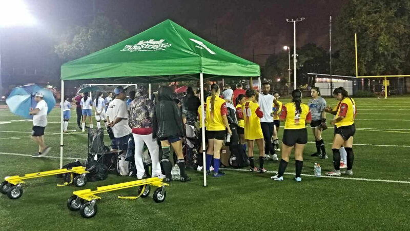 Members of the Colombia women's team take shelter from the rain