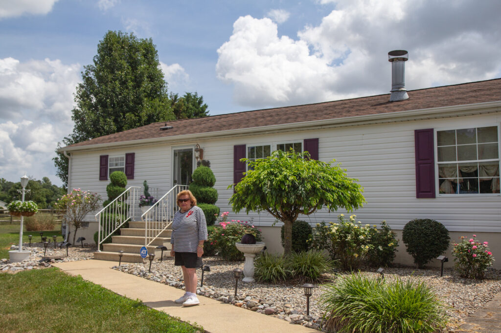 Diane Longo stands outside of her home.