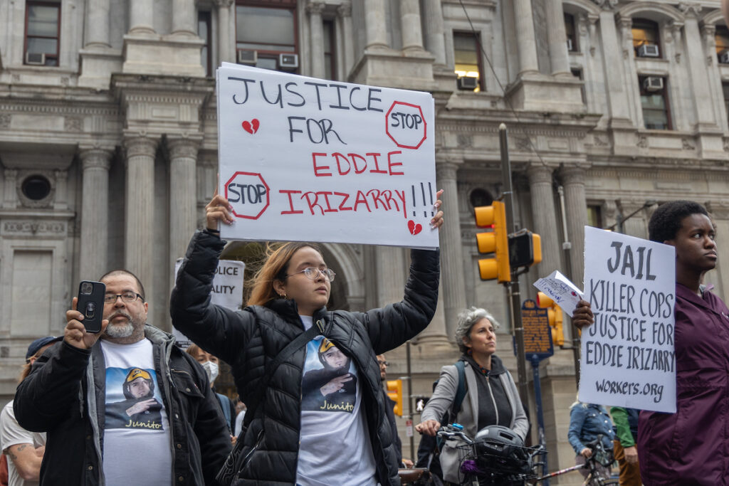 Eddie Irizarry's sister Maria holds up a sign reading "Justice for Eddie Irizarry."