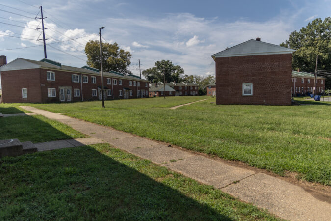 A sidewalk and grass visible near several rowhomes