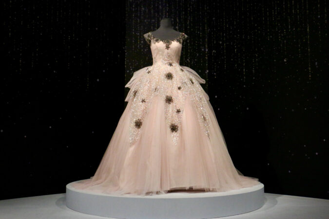 A pink and lace gown is displayed on a mannequin