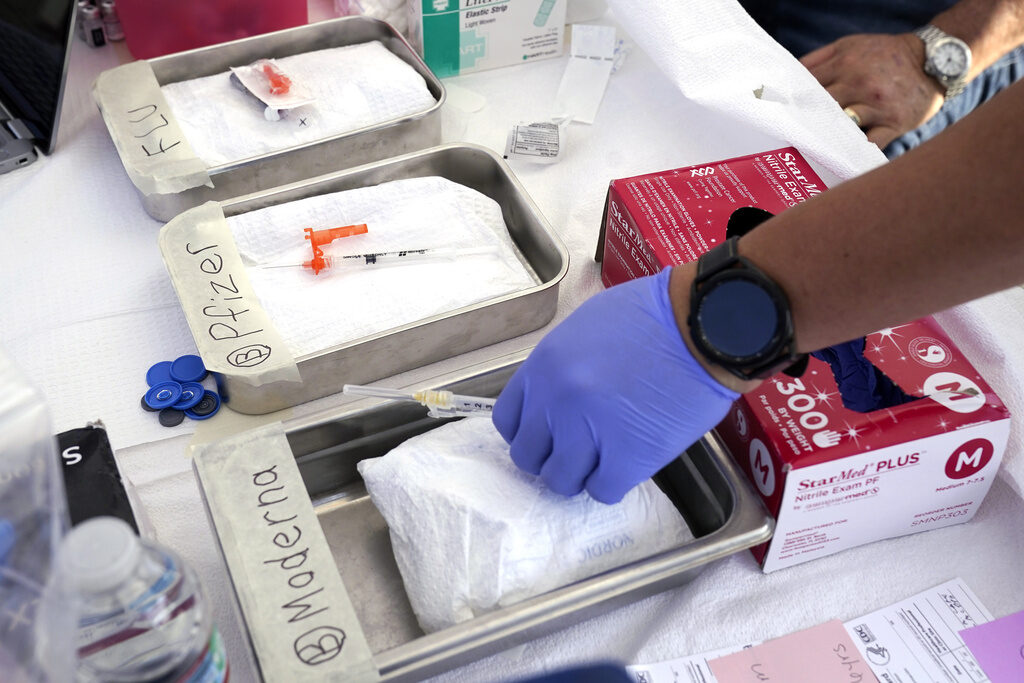 Virus Outbreak Vaccines Syringes with vaccines are prepared at the L.A. Care and Blue Shield of California Promise Health Plans' Community Resource Center where they were offering members and the public free flu and COVID-19 vaccines Oct. 28, 2022, in Lynwood, Calif. Updated COVID-19 vaccines in the latter half of 2023 come just in time to pair them with flu shots. (AP Photo/Mark J. Terrill, File)
