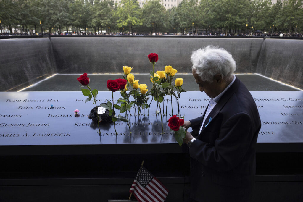 Sept 11 Anniversary Hagi Abucar puts flowers on the 9/11 Memorial during the commemoration ceremony on the 22nd anniversary of the September 11, 2001, terror attacks on Monday, Sept. 11, 2023, in New York