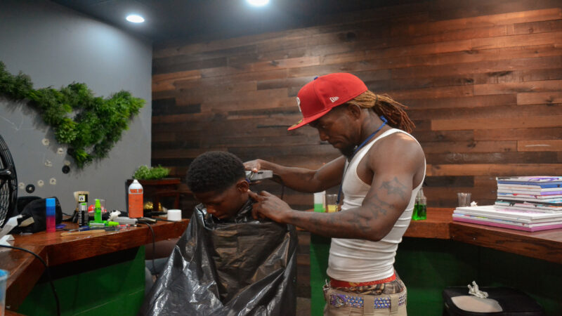 Volunteer barber provides free haircuts. Photo by Brianna Hill.