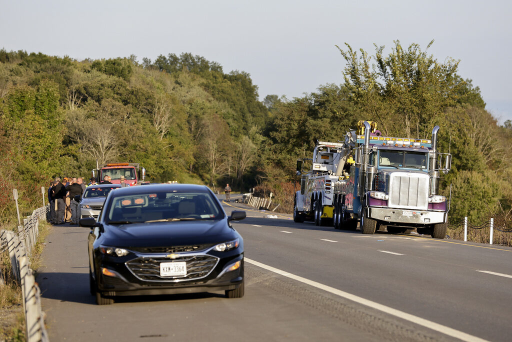 A car and emergency responders by the side of the road.