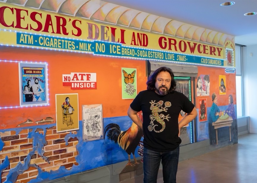 cesar-viveros-delaware-art-museum-1 Cesar Viveros poses for a photo in front of a mural and installation at the Delaware Art Museum
