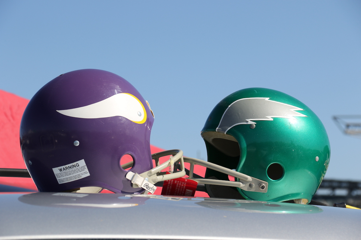 A retro Minnesota Vikings helmet faces a retro Philadelphia Eagles helmet.