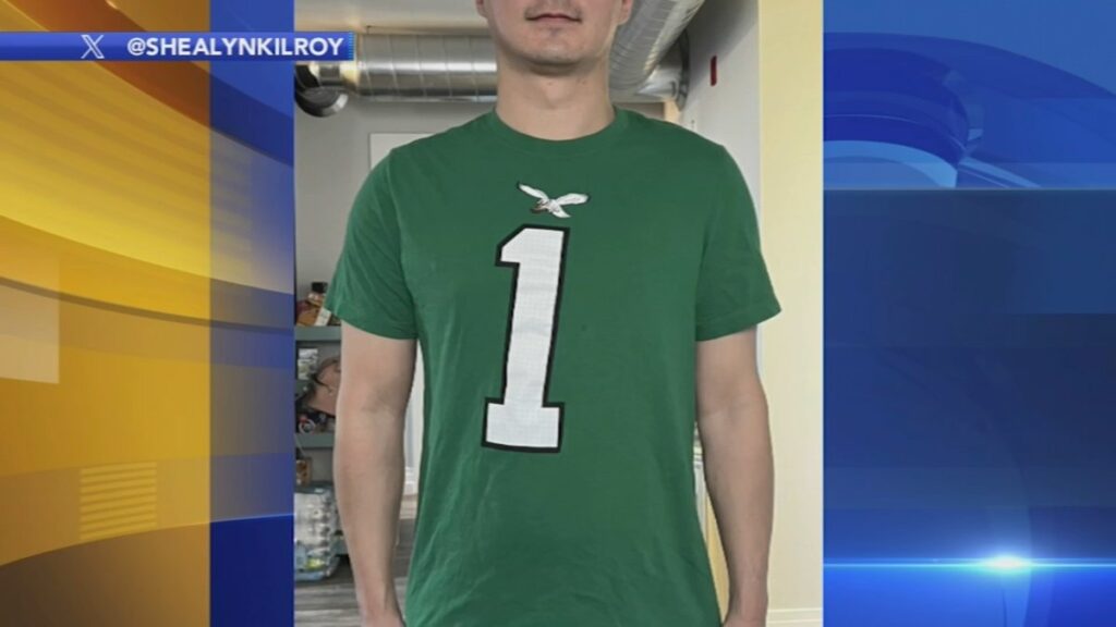 A person wearing a kelly green jersey with a crooked number one on it.