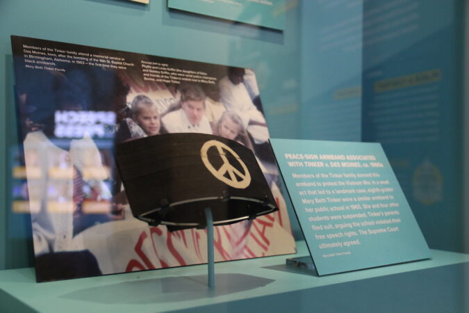 An armband with a peace sign in a glass display case