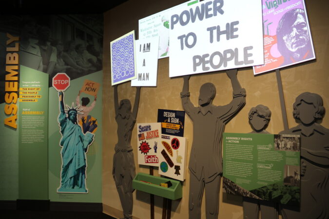 Cardboard silhouettes hold protest signs.