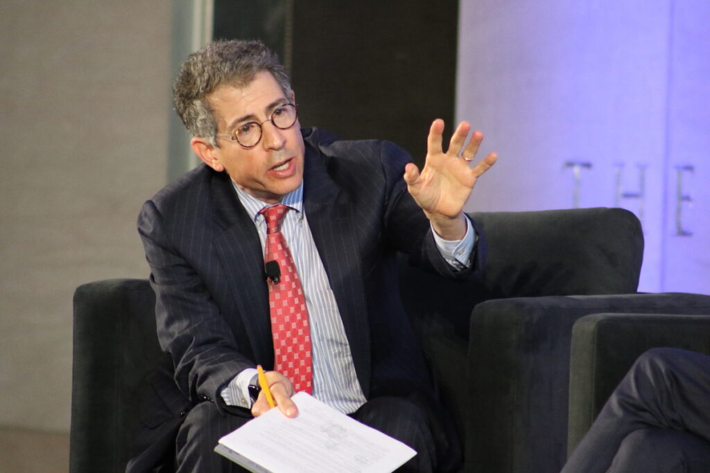 Bruce Brown gestures as he speaks while seated onstage.
