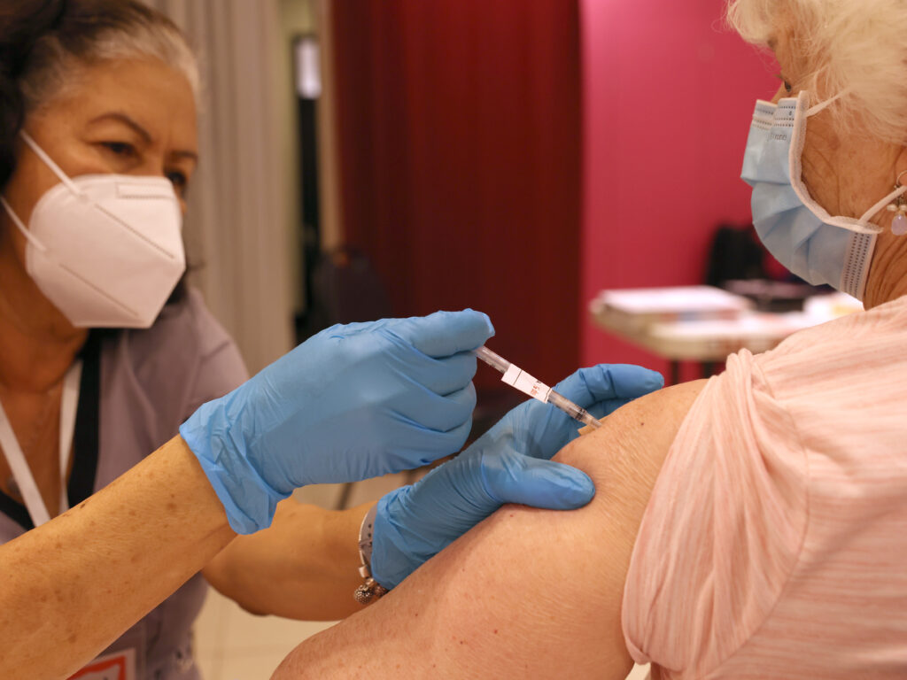 Another round of COVID-19 vaccines is on the way. The Food and Drug Administration approved vaccines from Pfizer and Moderna that target an omicron subvariant called XBB.1.5. Vaccination campaigns, like this one in San Rafael, Calif., in 2022, could resume soon. doctor giving a shot