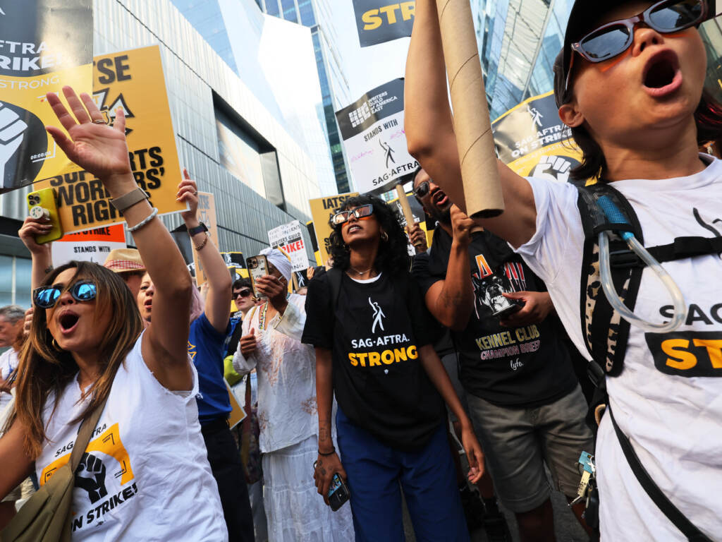 People hold signs as members of SAG-AFTRA and Writers Guild of America East walk a picket line outside of the HBO/Amazon offices during the National Union Solidarity Day in New York City on Aug. 22, 2023. Labor unions have notched some big victories this year but organized labor still faces an uncertain future. workers marching