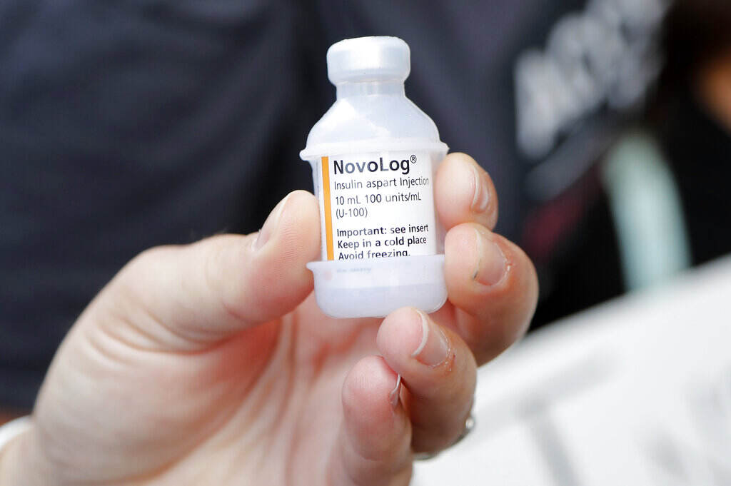Elections 2020 Bernie Sanders A close-up of a person's hand holding up a vial of insulin.