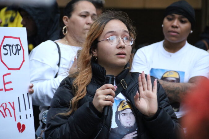 Eddie Irizarry Jr.'s sister Maria speaks into a microphone.