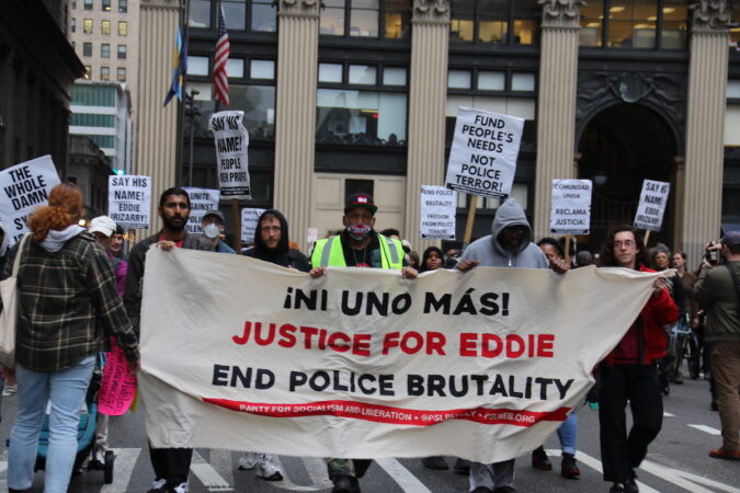 Protesters hold a sign that reads 