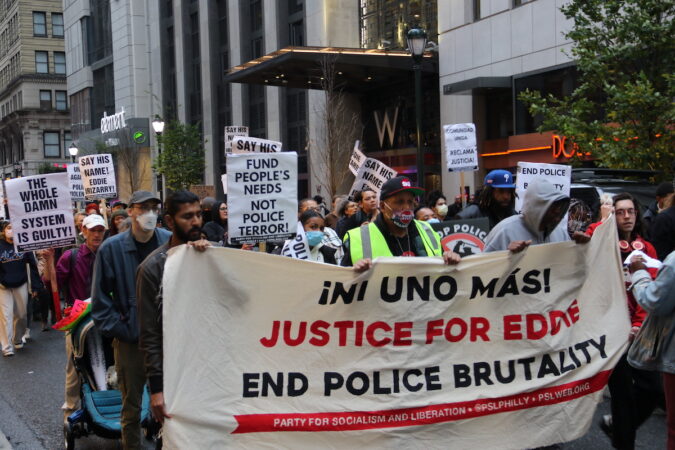 Protesters hold a sign that reads 