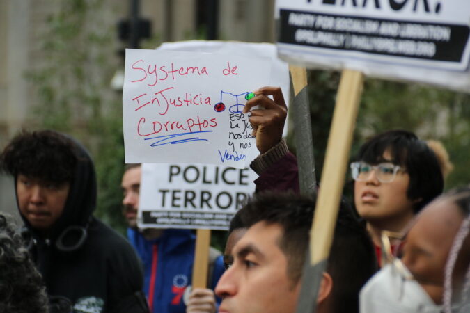 Protesers hold a sign that reads 