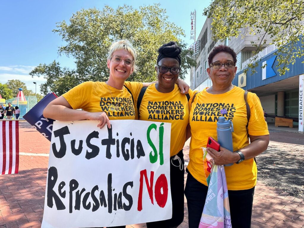 Three women wearing yellow shirts that say 'National Domestic Workers Alliance'