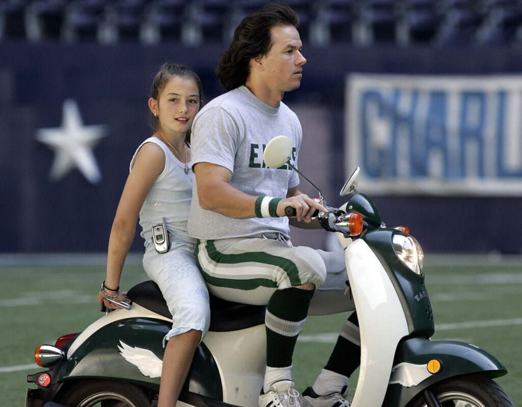 WAHLBERG PAPALE Actor Mark Wahlberg, right, rides a moped with Gabriella Papale, daughter of Vince Papale, on the football field at Texas Stadium during a break in the filming a scene of a 1976 football game between the Dallas Cowboys and Philadelphia Eagle for the motion picture titled Invincible in Irving, Texas, Wednesday, Oct. 19 , 2005. In the film based on a true story, Wahlberg plays Vince Papale an Eagle's fan with no organized football experience that answered a open tryout call and won a roster spot. (AP Photo/LM Otero)