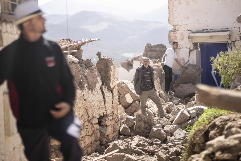 CORRECTION Morocco Earthquake People stand on the rubble left behind from an earthquake in Morocco.