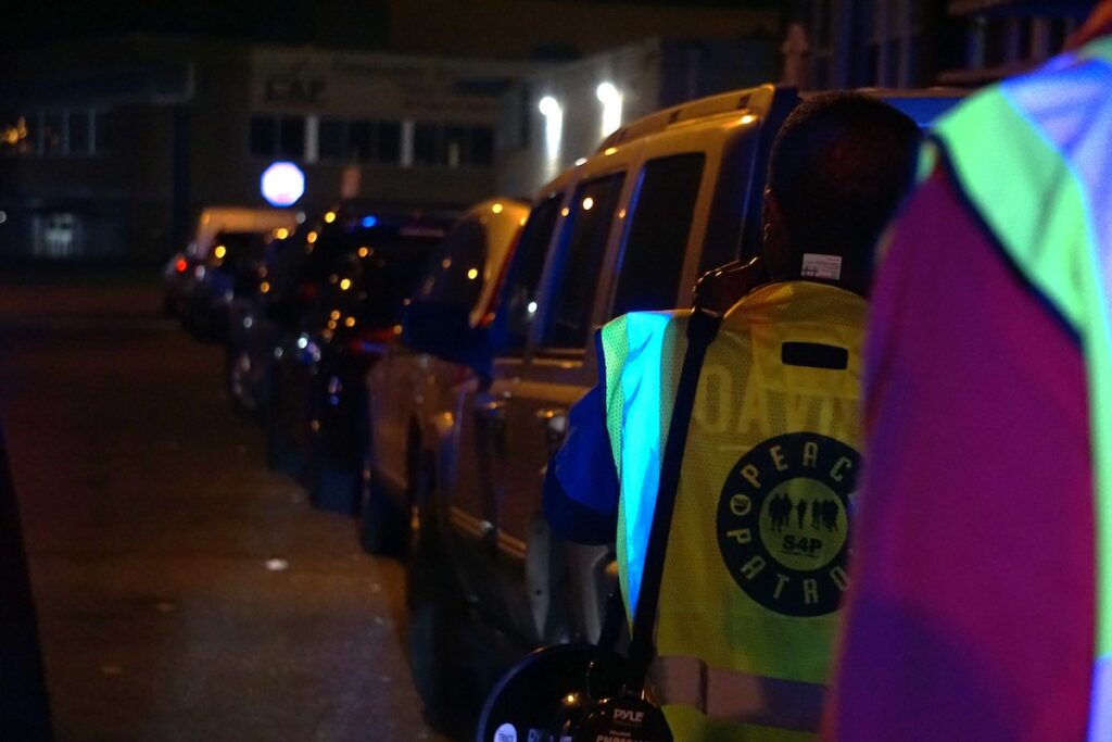 Emmanuel Bussie leads volunteers down a street.