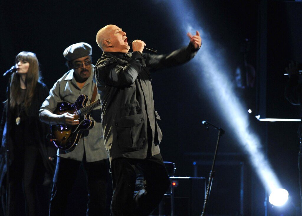 Peter Gabriel sings into a microphone onstage